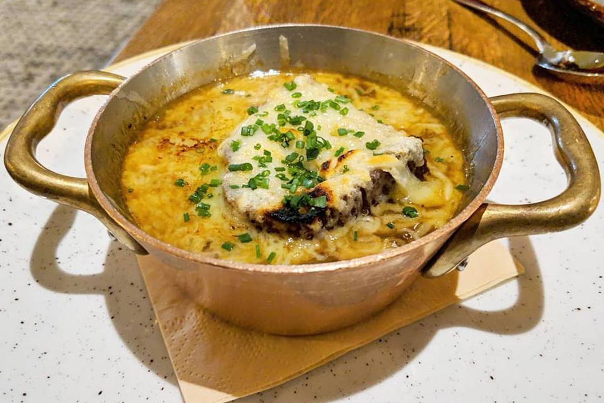 Cheesy French onion soup in a gold bowl