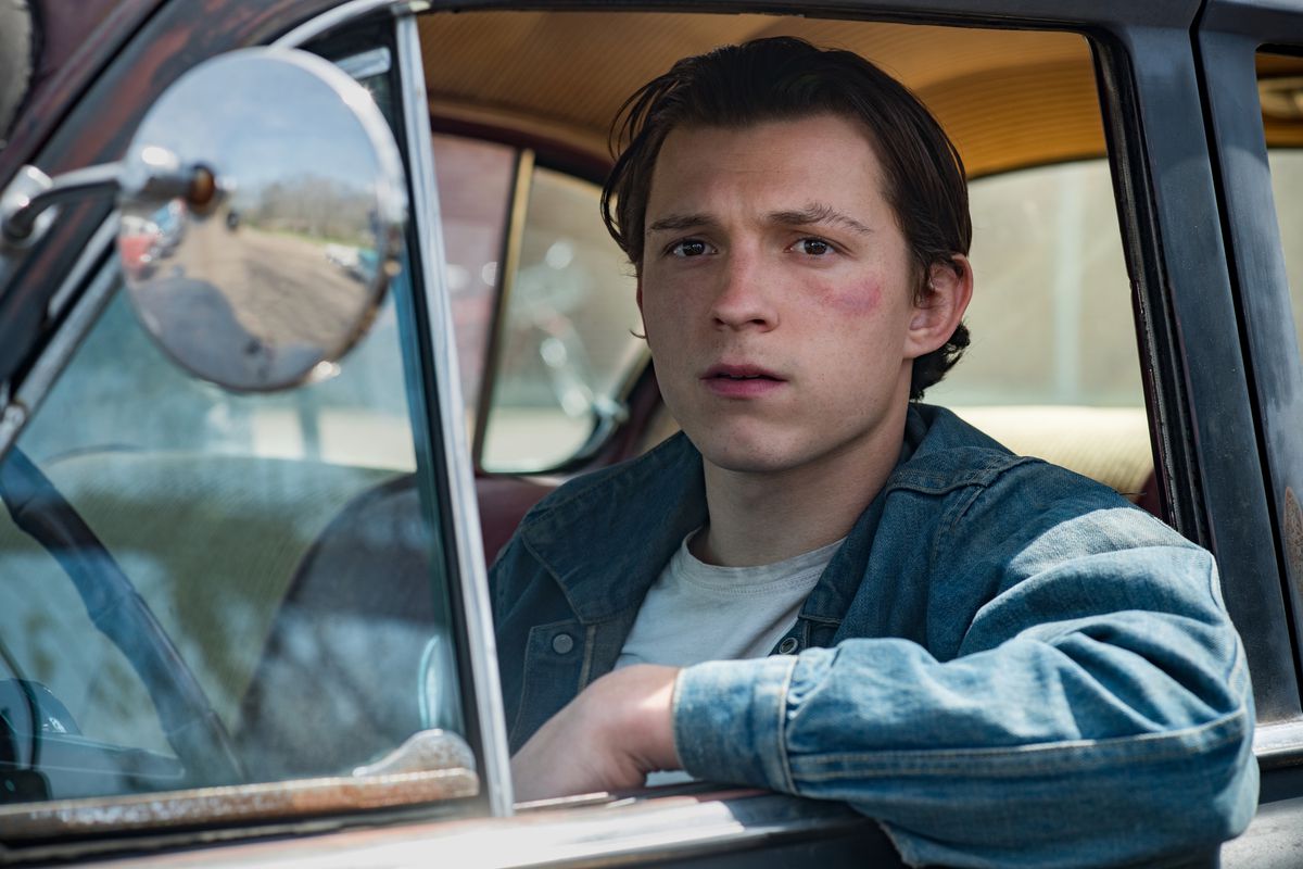 tom holland stares wistfully out the window of a car