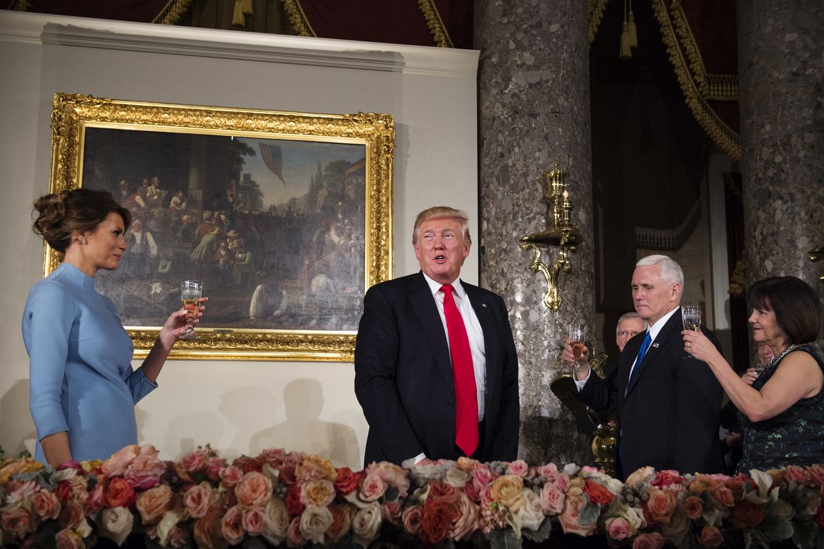 President Donald Trump stands while toasted by first lady Melania, Vice President Mike Pence, and his wife Karen during the Inaugural Luncheon.