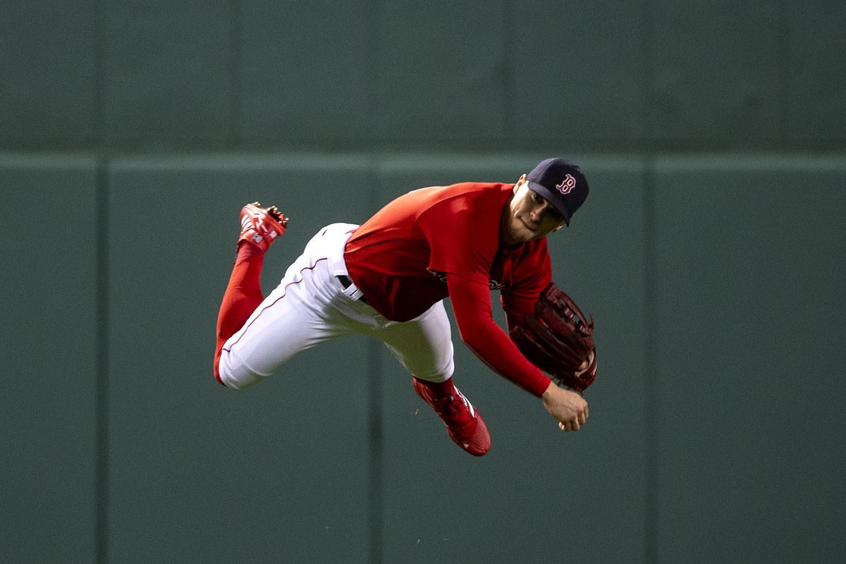 Enrique Hernandez #5 of the Boston Red Sox falls as he throws during the fourth inning of game three of the 2021 American League Championship Series against the Houston Astros at Fenway Park on October 18, 2021 in Boston, Massachusetts.