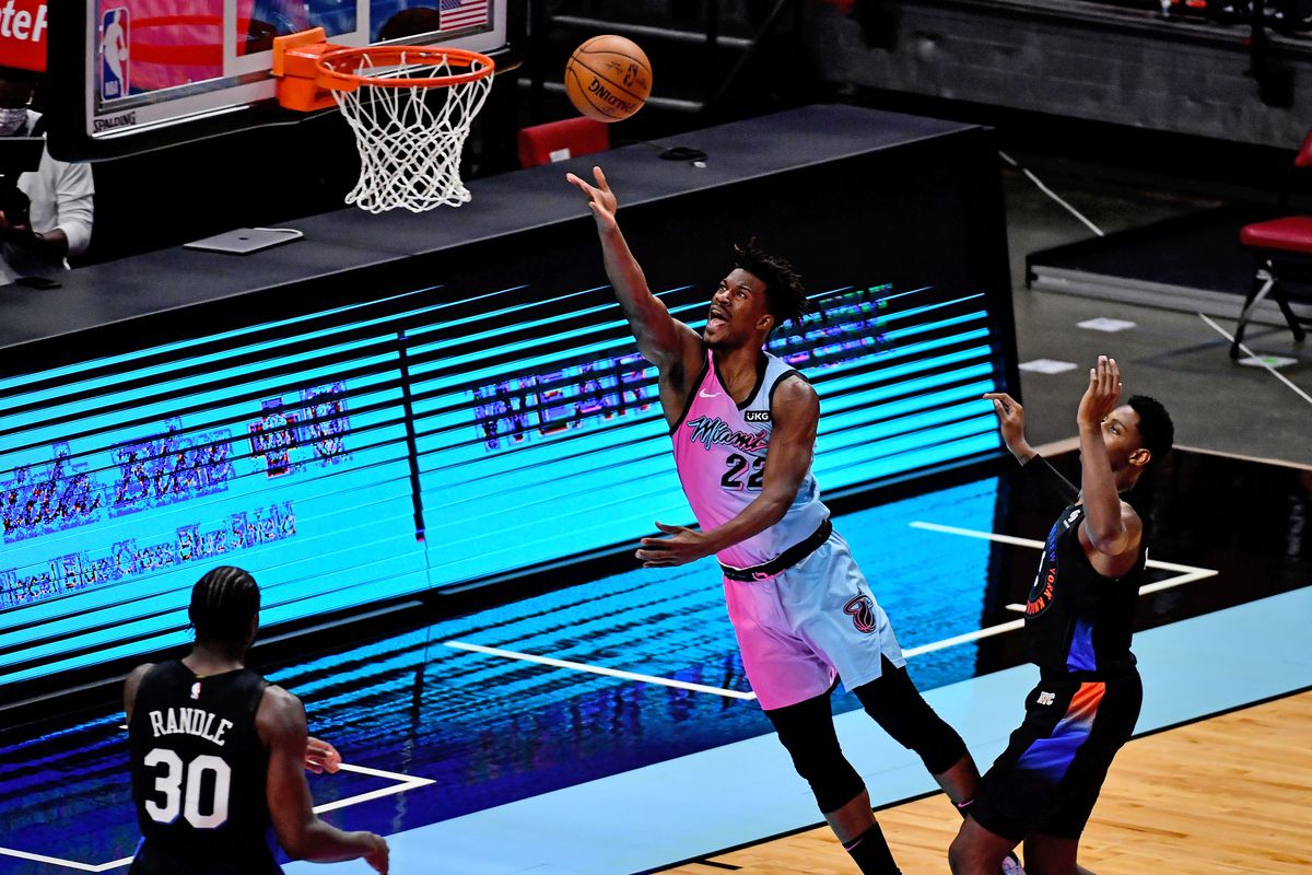 Miami Heat forward Jimmy Butler (22) attempts a shot around New York Knicks guard RJ Barrett (9) during the first half at American Airlines Arena.