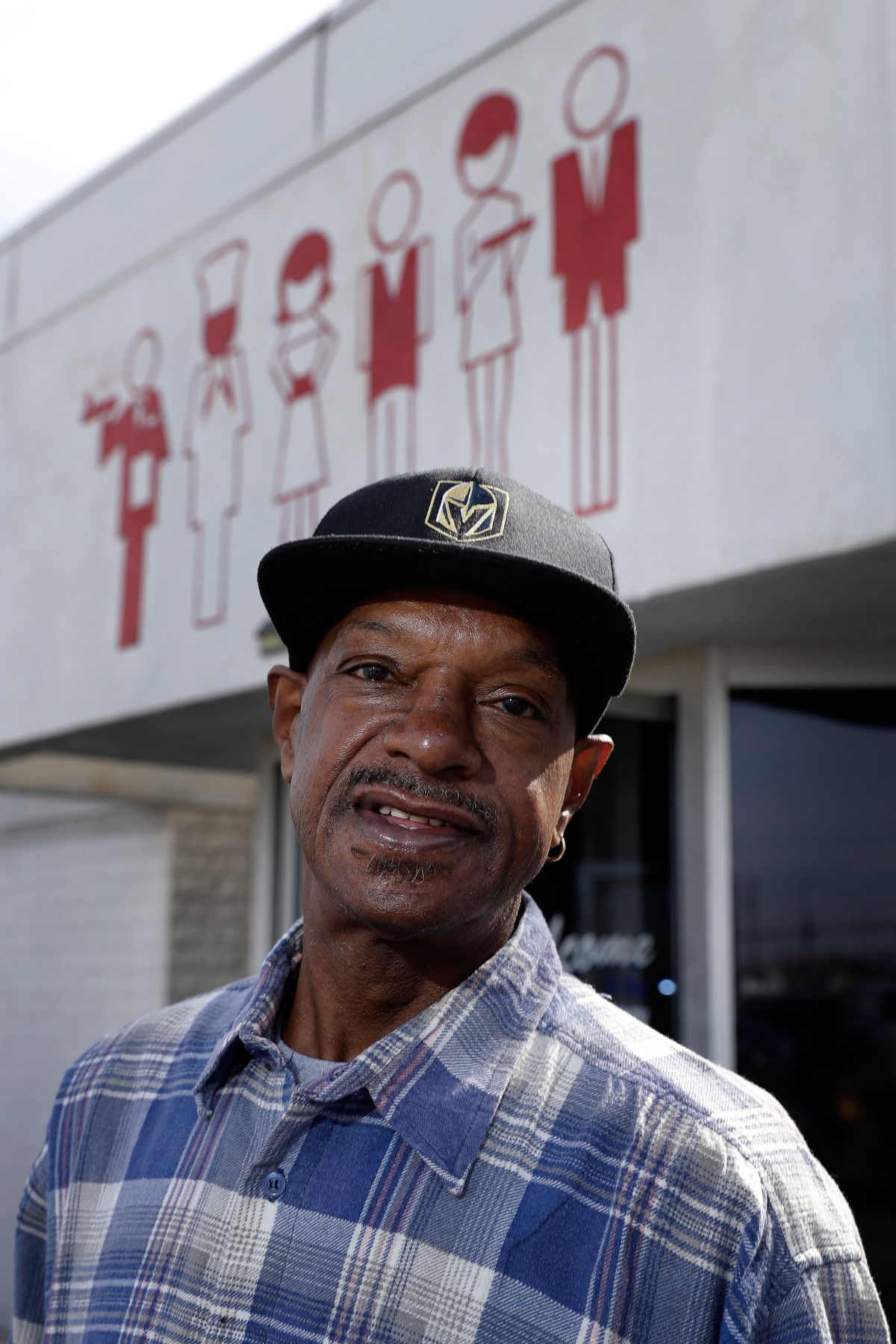 A man in a black cap and checked shirt poses outside the Culinary Union hall.