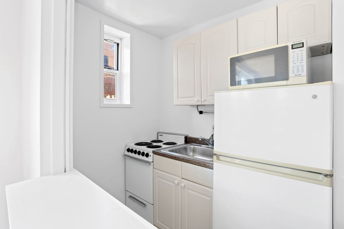 A small kitchen with white cabinetry.