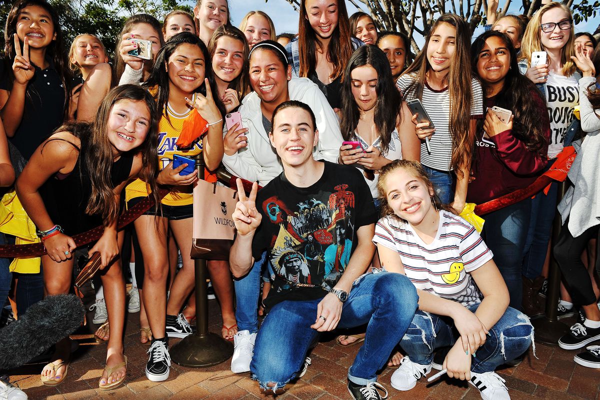 Nash Grier and Baby Ariel pose in front of a group of young fans.