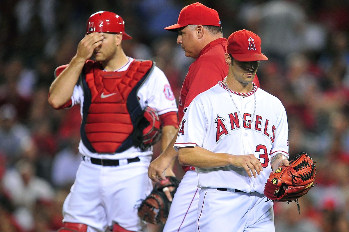 September 19, 2012; Anaheim, CA, USA; Los Angeles Angels starting pitcher C.J. Wilson (33) is relieved by manager Mike Scioscia (14) in the third inning against the Texas Rangers at Angel Stadium. Mandatory Credit: Gary A. Vasquez-US PRESSWIRE