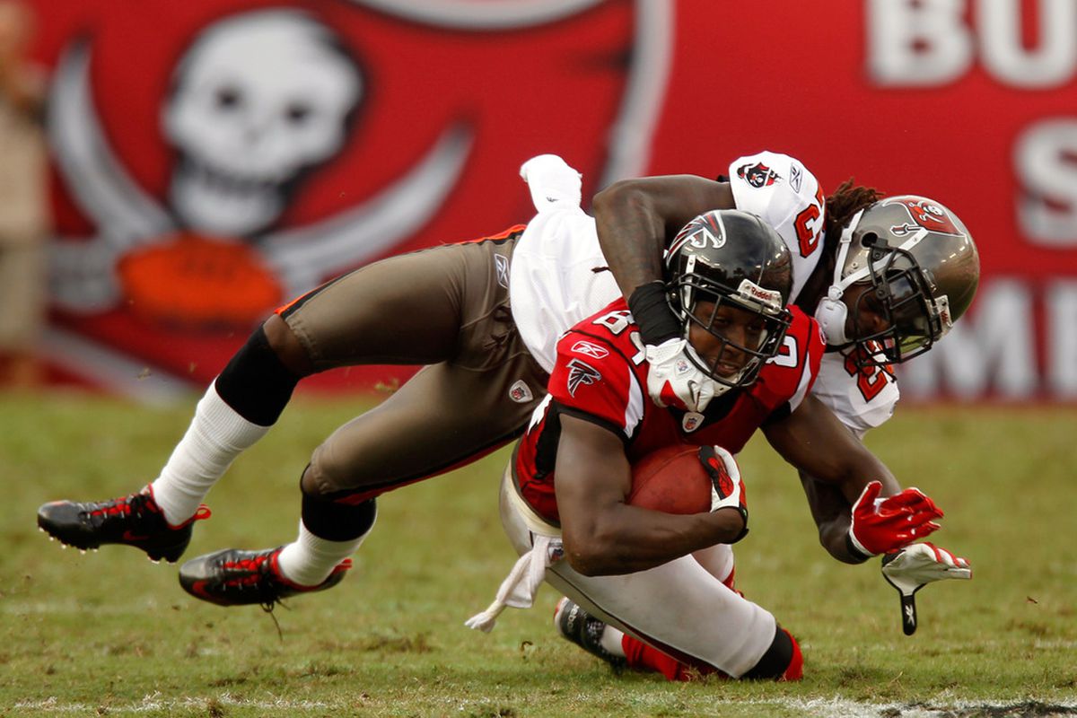 TAMPA, FL - SEPTEMBER 25:  Nathan Overbay #84 of the Atlanta Falcons is tackled by Myron Lewis #23 of the Tampa Bay Buccaneers at Raymond James Stadium on September 25, 2011 in Tampa, Florida.  (Photo by Mike Ehrmann/Getty Images)