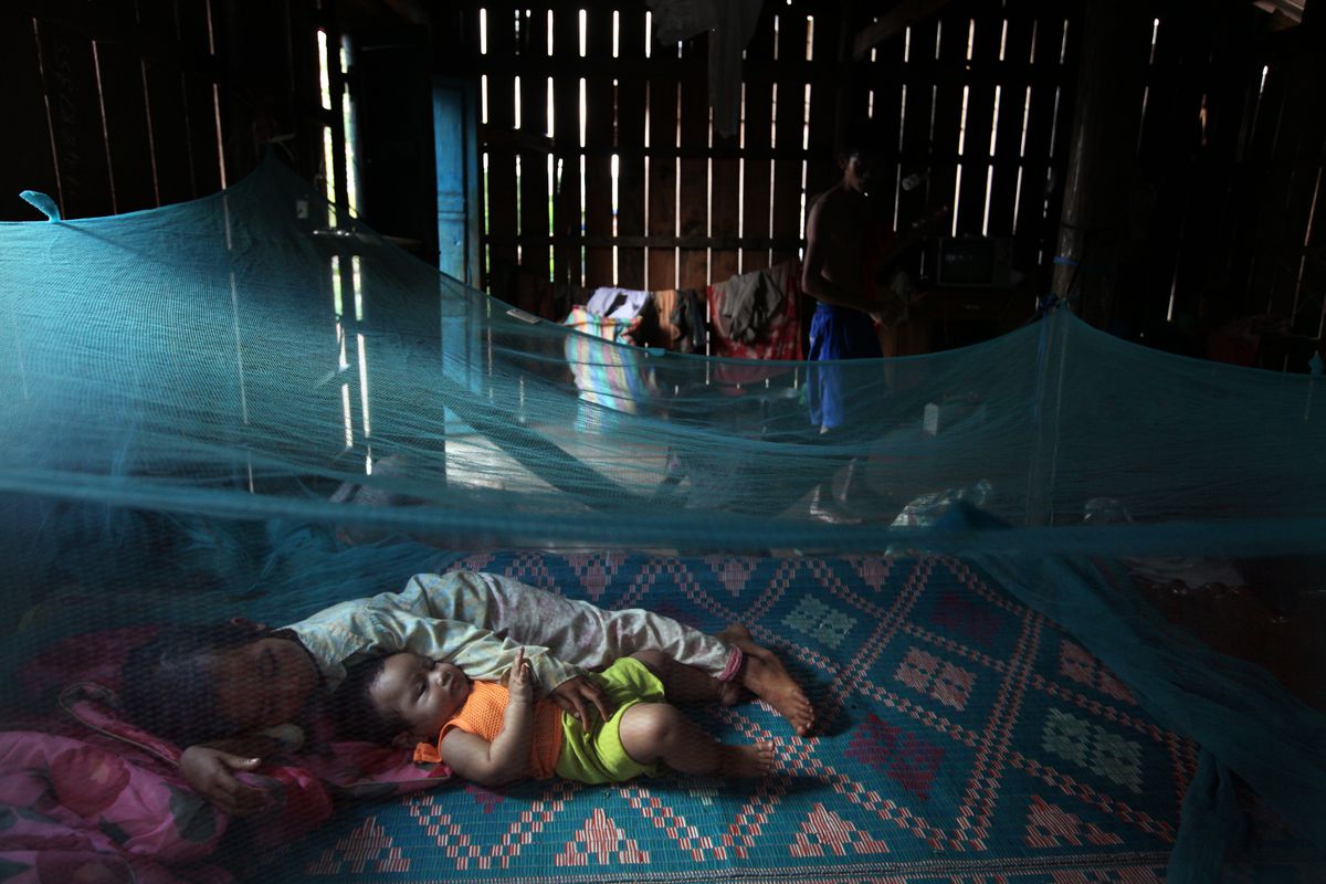 Children in Cambodia sleeping under a bednet for malaria protection.