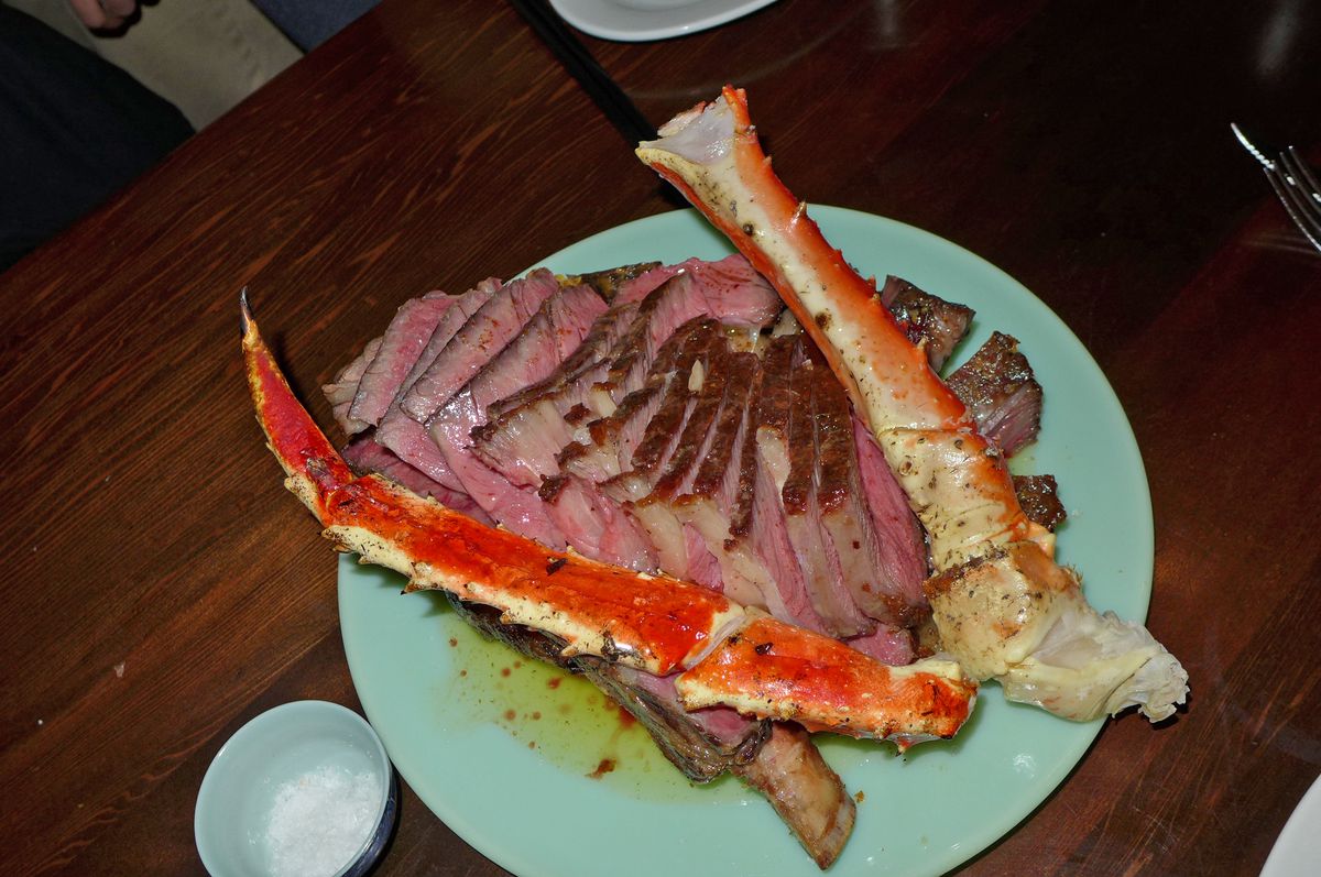 Sliced red meat underneath, crab legs on top.