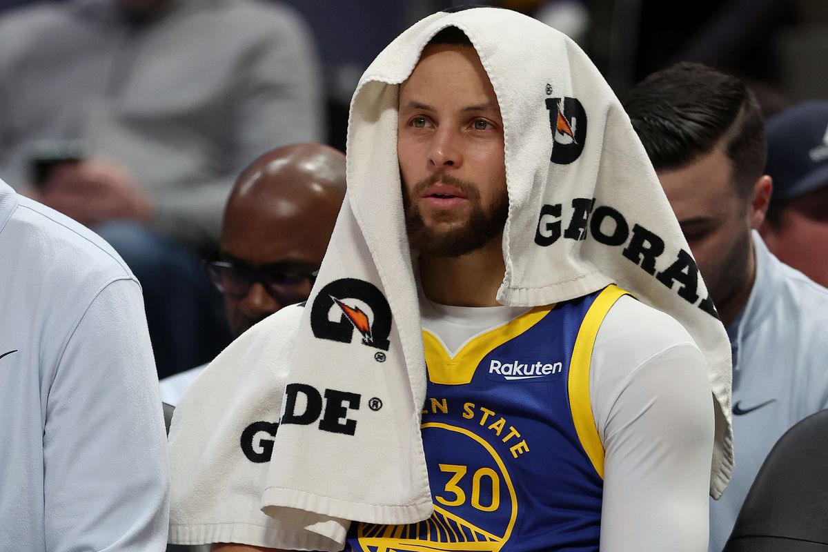 Stephen Curry of the Golden State Warriors watches from the bench as his team plays the Denver Nuggets in the fourth quarter at Ball Arena on February 2, 2023 in Denver, Colorado.&nbsp;