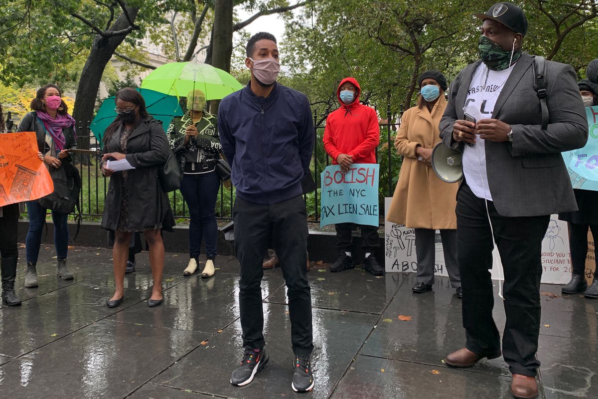 Council member Antonio Reynoso, left, and Al Scott, a homeowner and organizer with East New York Community Land Trust Initiative, speak outside City Hall during a rally demanding an end to the city’s tax lien sales, October 13, 2020.
