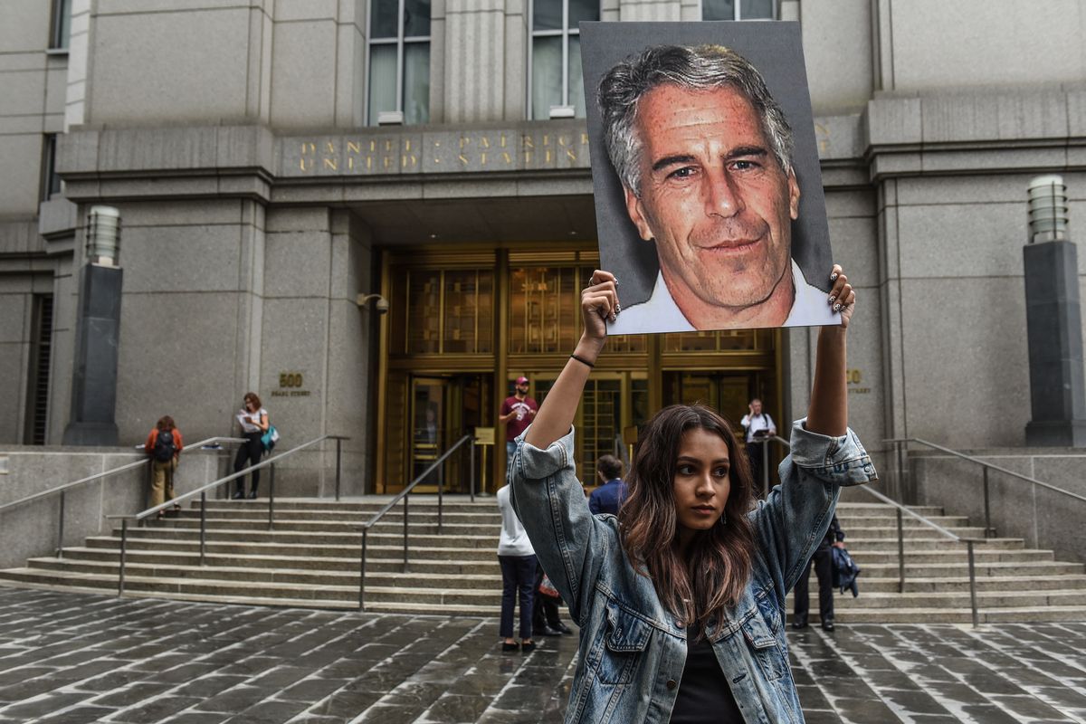 A protester holds up a sign of Jeffrey Epstein’s face in front of the federal courthouse in New York City after his arrest.
