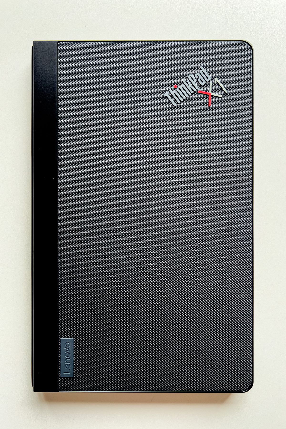 Le ThinkPad X1 Fold fermé sur une table blanche.