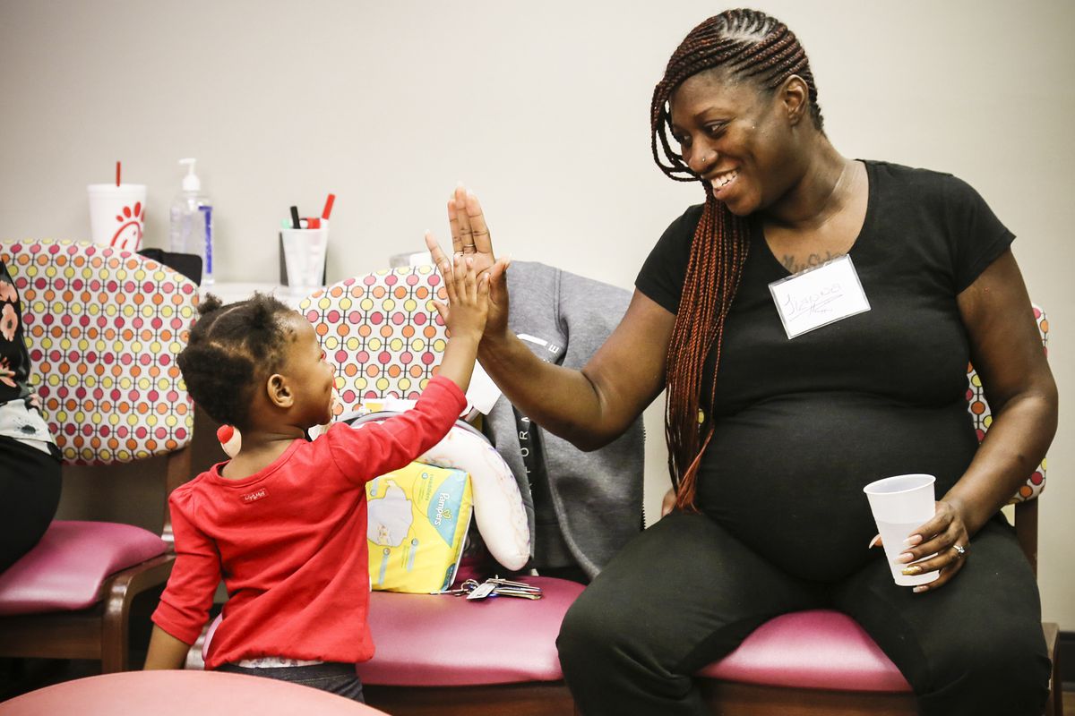 Tianna Blakely and her daughter Anika Edmond share a moment during prenatal group time.