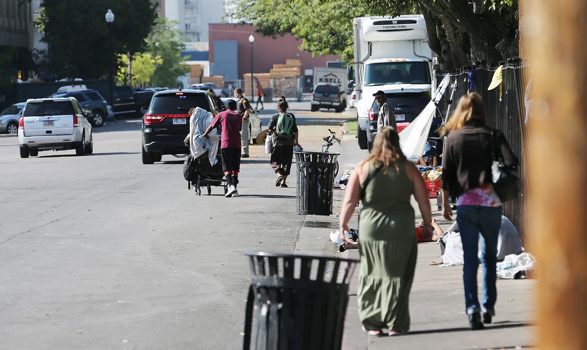 FILE - Homeless people leave the area around the Road Home shelter as police conduct Operation Rio Grande in Salt Lake City on Monday, Aug. 14, 2017.