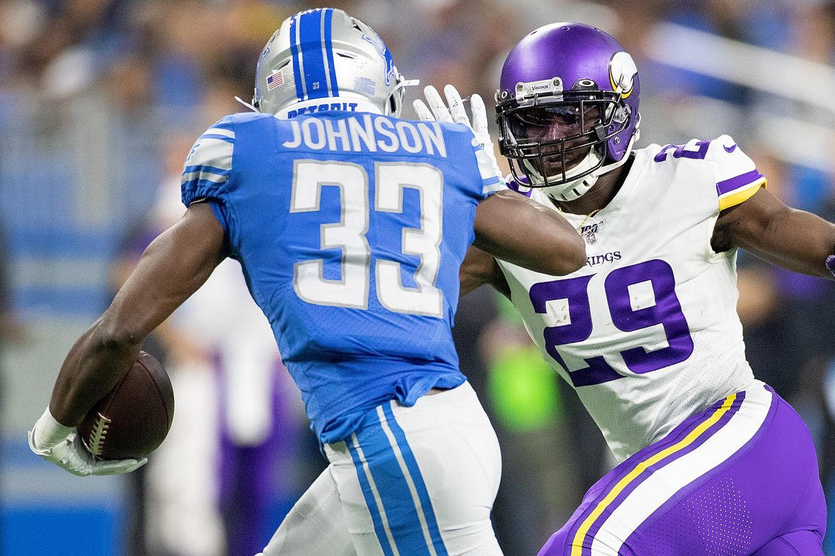 Kerryon Johnson of the Detroit Lions runes for a short gain as Xavier Rhodes of the Minnesota Vikings gets ready to make the top during the first quarter of the game at Ford Field on October 20, 2019 in Detroit, Michigan.