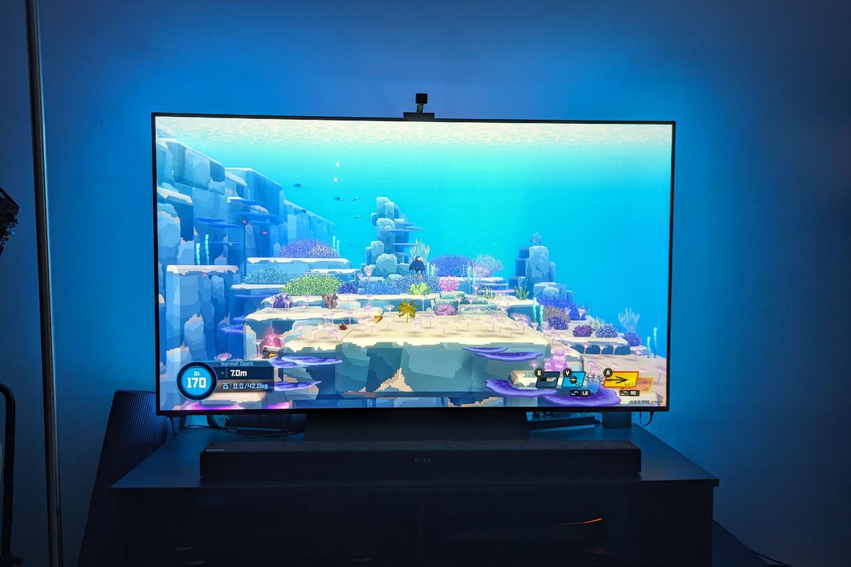 An image showing the author’s TV, which is equipped with Govee’s backlights. On the screen, Dave the Diver is shown with its oceanic background. Thanks to the backlights, the blue background is being spread onto the walls behind his TV.