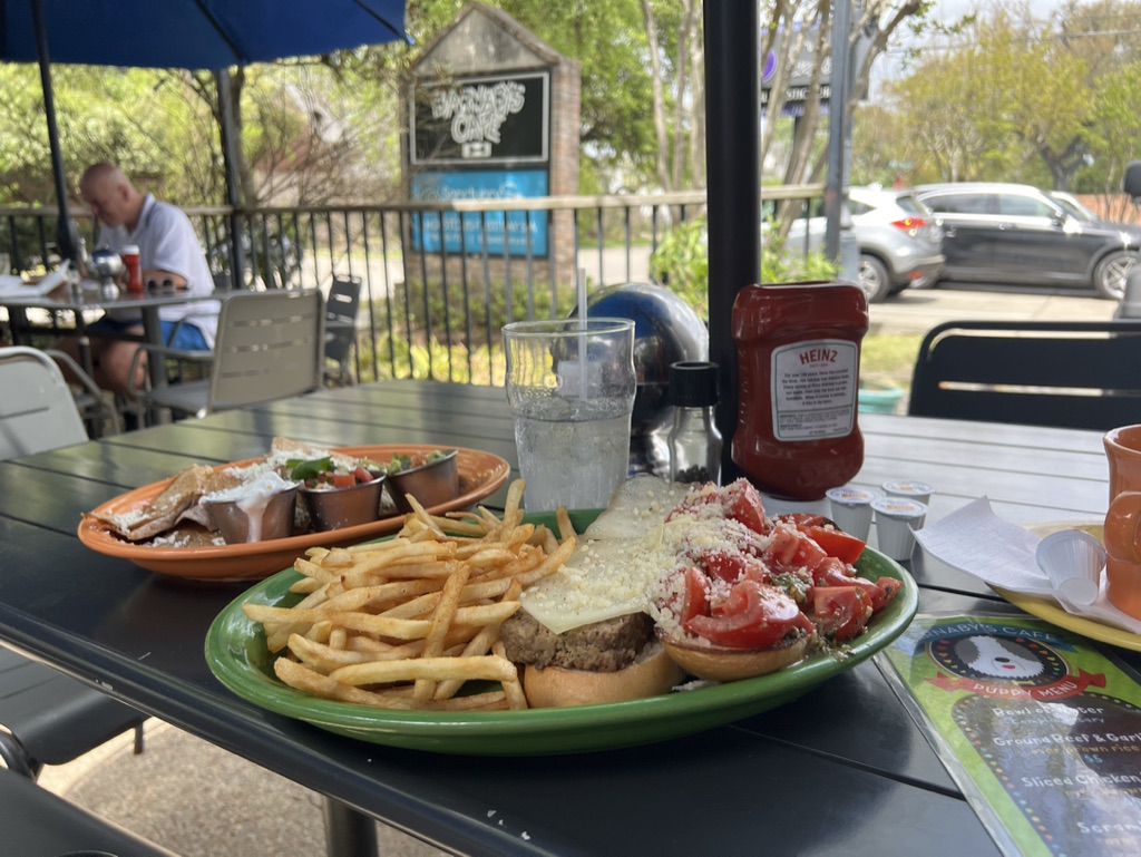A plate of bruschetta meatloaf sandwich and fries and a chicken tinga quesadilla on the patio at Barnaby’s Cafe.