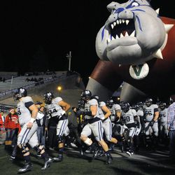 The Utah State Aggies run out onto the field for the Mountain West football championship game at Bulldog Stadium in Fresno, Calif., on Saturday, Dec. 7, 2013.