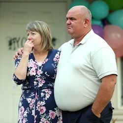 Doug and Tracy Julian listen as members of the Salem Hills High School football team sing "Nearer, My God to Thee" on the front lawn of their Woodland Hills home on Sunday, Aug. 6, 2017. The couple's son, also named Doug, died Saturday of apparent altitude sickness while on a Boy Scout outing in the High Uintas. He was also a member of the football team.