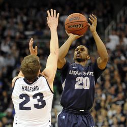 Utah State Aggies guard TeNale Roland (20) shoots over Brigham Young Cougars guard Skyler Halford (23) during a game at EnergySolutions Arena on Saturday, November 30, 2013.