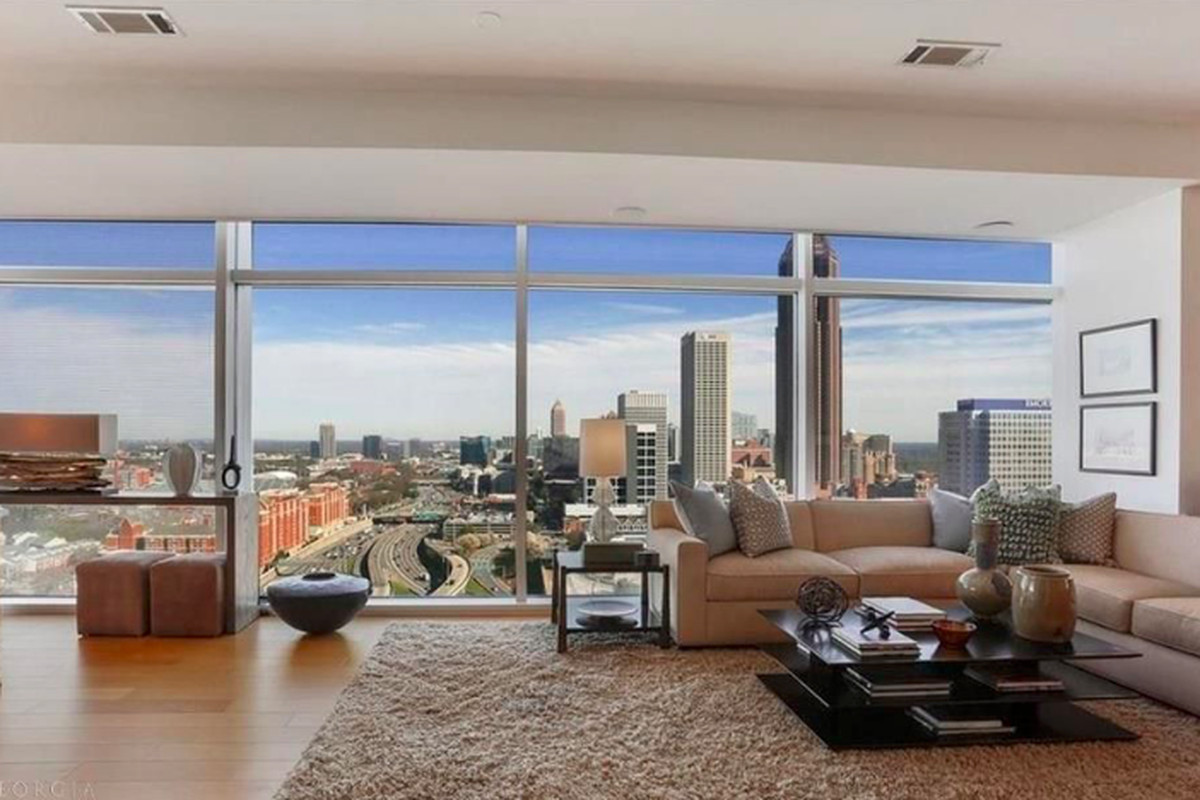 A large condo with huge windows looking out onto the city of Atlanta.