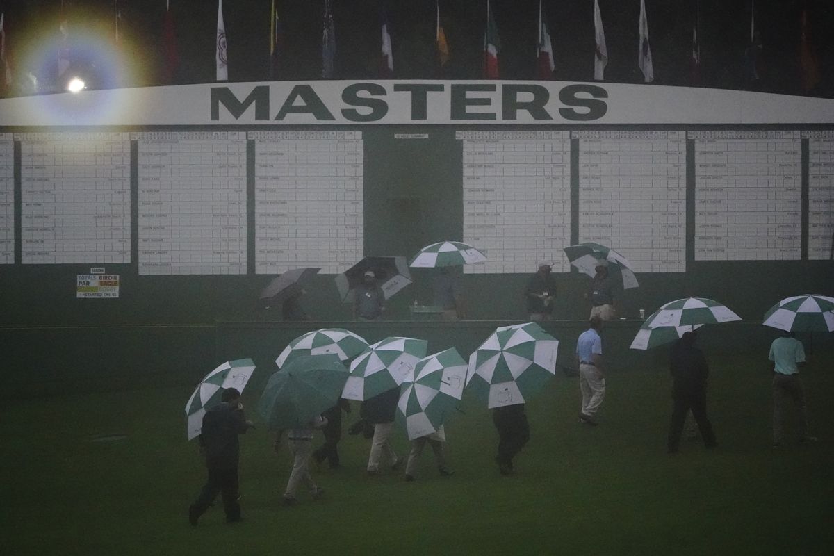 Officials leave the Augusta National Golf Course after play was suspended during the first round of the Masters.