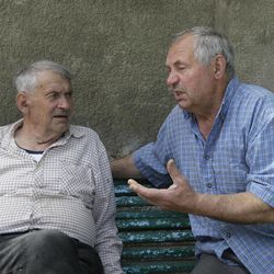 In this picture taken May 10, 2013, Heorhiy Syvyi, 78, left, and Ivan Hrushka share their war memories in their home village of Pidhaitsi close to Ukraine's western city of Lutsk.  Nearly two dozen civilians, primarily women and children, were slaughtered in Pidhaitsi.  Evidence uncovered by AP indicates that Ukrainian Self Defense Legion commander Michael Karkoc's unit was in the area at the time of the massacre. There is no indication any other units were in the area at the time. Heorhiy Syvyi was a 9-year-old boy when troops swarmed into town on Dec. 3 and managed to flee with his father and hide in a shelter covered with branches. His mother and 4-year-old brother were killed.   