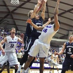 BYU's Chase Fischer and Ryan Andrus, rear, defend Portland's Kevin Bailey (00) during the second half of an NCAA college basketball game in Portland, Ore., Thursday, Feb. 26, 2015. BYU won 82-69.
