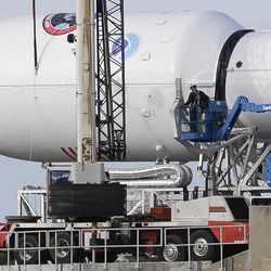 Maintenance is performed by workers on the Falcon 9 SpaceX rocket at launch complex 40 at the Cape Canaveral Air Force Station in Cape Canaveral, Fla., Monday, Feb. 9, 2015. The Sunday launch attempt was scrubbed and SpaceX will try again on Tuesday evening. 