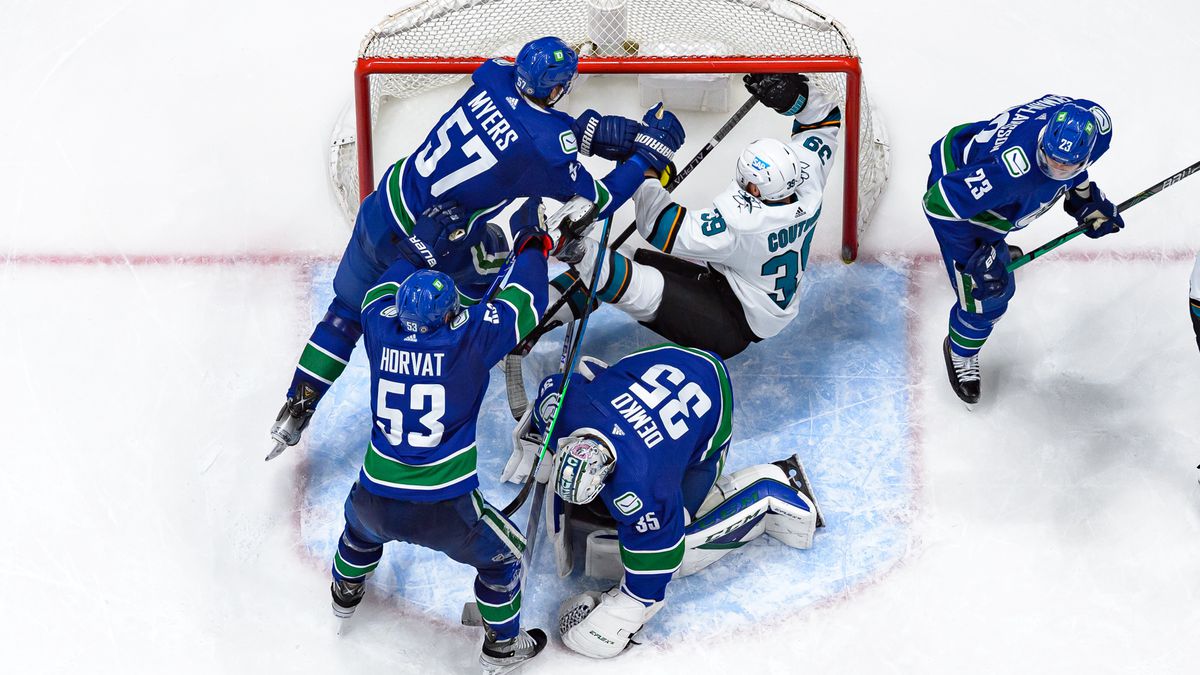 Apr 9, 2022; Vancouver, British Columbia, CAN; Vancouver Canucks defenseman Tyler Myers (57) checks San Jose Sharks center Logan Couture (39) as Vancouver Canucks goaltender Thatcher Demko (35) makes a save in the third period at Rogers Arena. Vancouver won 4-2.