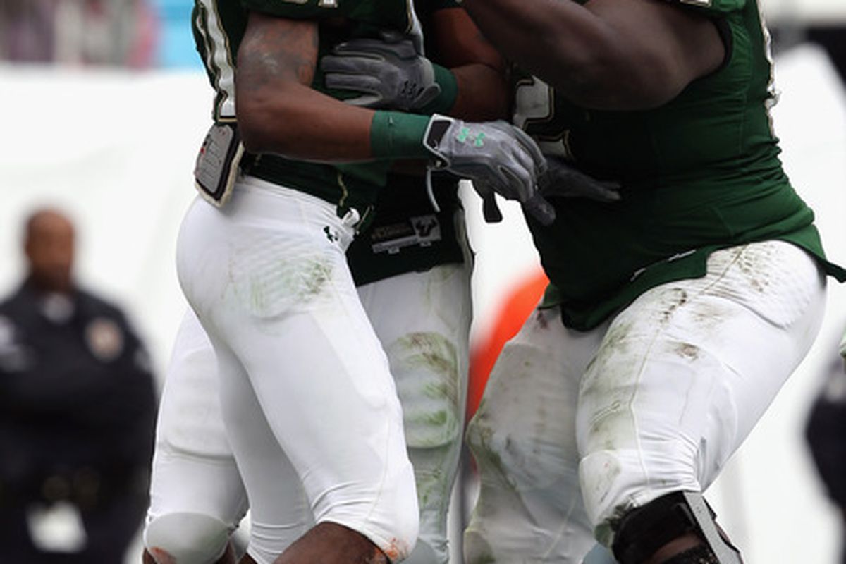 CHARLOTTE NC - DECEMBER 31:  Dontavia Bogan #81 of the USF Bulls celebrates after scoring a touchdown with teammate Sampson Genus #62 and we assume Craig Marshall on being signed to NFL contracts.(Photo by Streeter Lecka/Getty Images)