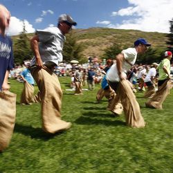 Older kids and adults race in a potato sack race in Park City in 2012.