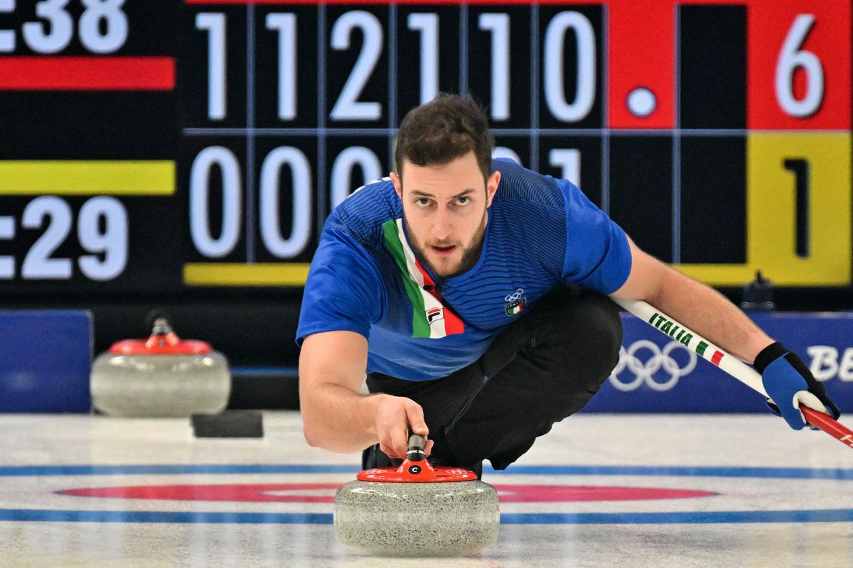 Italy’s Amos Mosaner curls the stone during the mixed doubles semifinal game of the Beijing 2022 Winter Olympic Games curling competition between Italy and Sweden, at the National Aquatics Centre in Beijing on February 7, 2022. (Photo by Lillian SUWANRUMPHA / AFP)