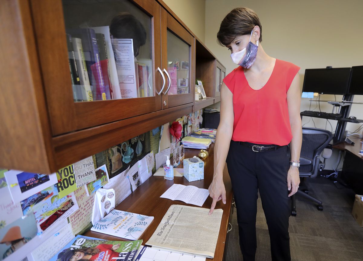 State epidemiologist Dr. Angela Dunn shows an issue of the New York Times that she keeps as a reminder of the lives lost to COVID-19 in her office at the Utah Department of Health in Salt Lake City on Monday, Aug. 24, 2020. At the time the issue was published, the virus had claimed more than 100,000 people.