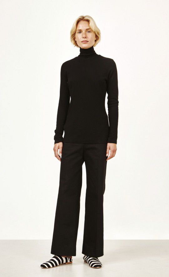 Model in black turtleneck and black trousers.