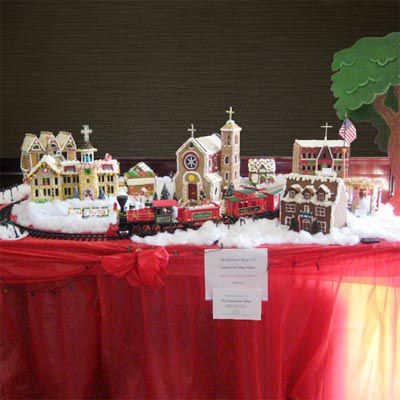 A gingerbread village with with 3 chapels and a house.
