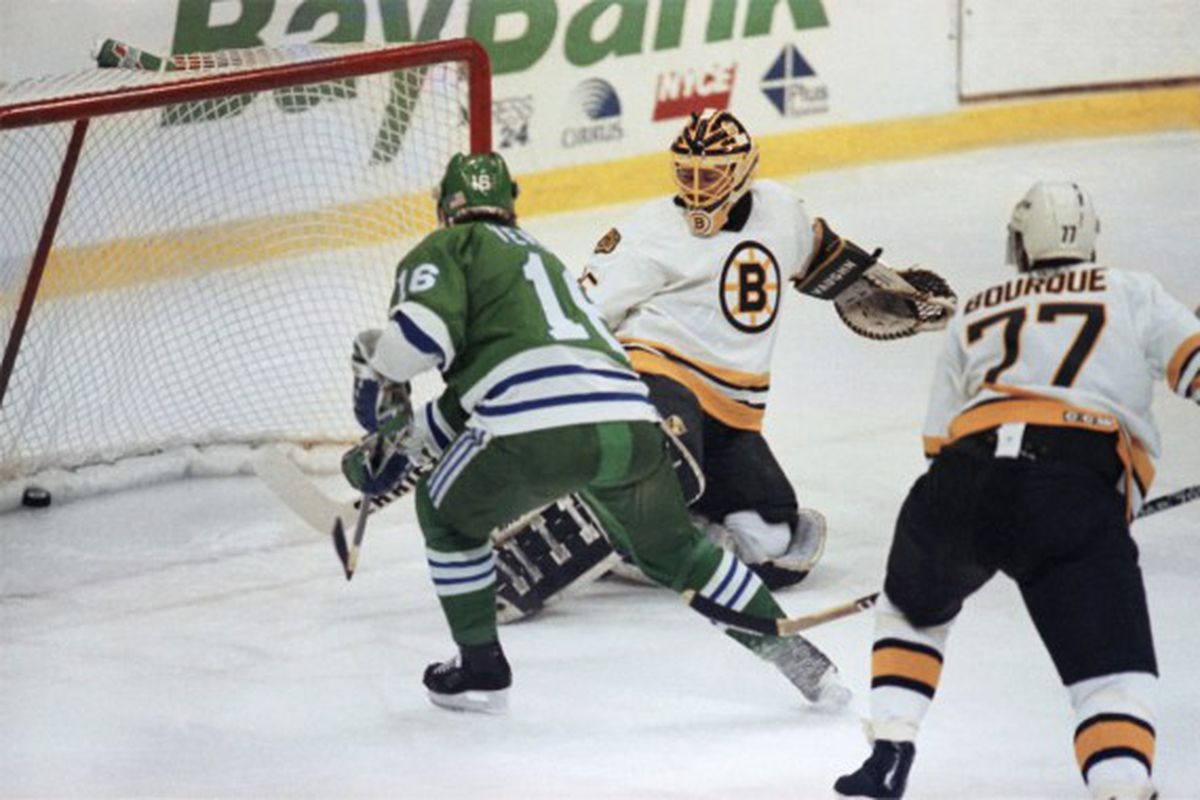 Pat Verbeek skates past Ray Bourque and shoots one past goaltender Andy Moog during the 1990 Adams Division playoffs. 