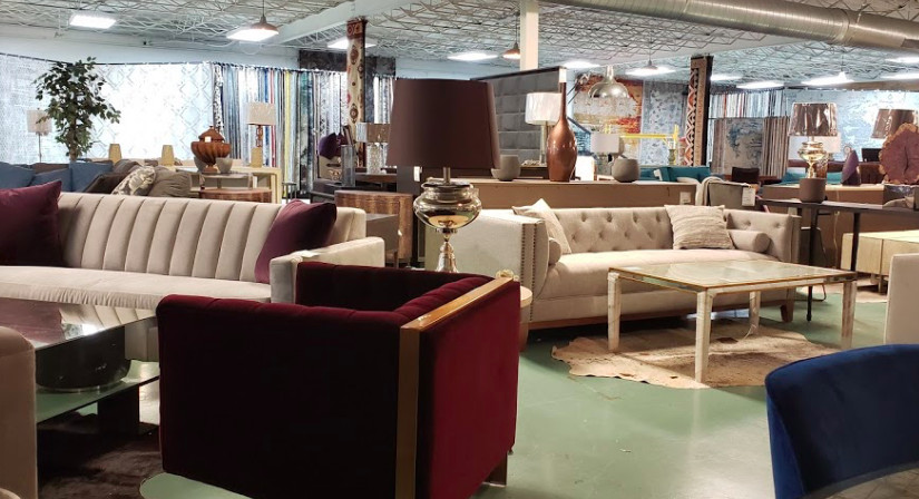 A furniture showroom with many couches and huge windows along a far wall. 