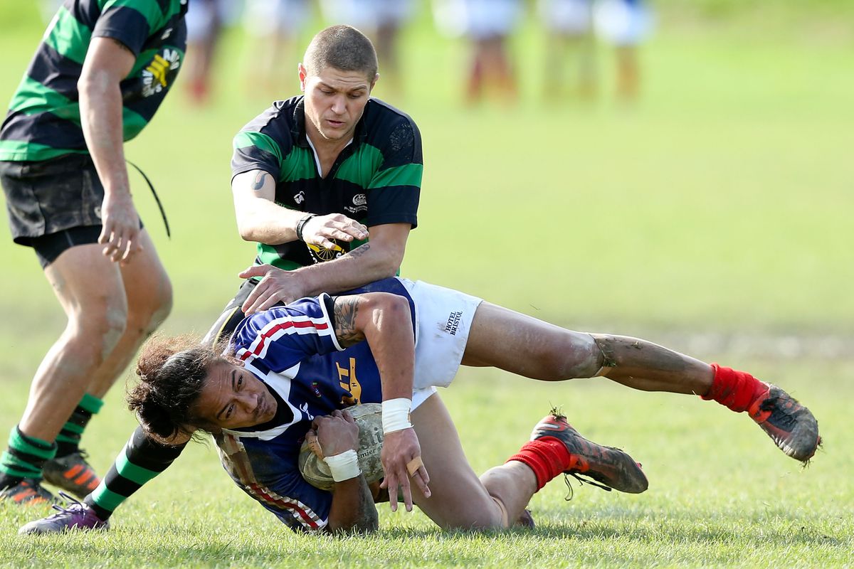 The original caption for this is fantastic:  Steven Johnson of Wests is tackled by Cory du Cart of Wainuiomata during the Wellington club rugby match between Wests Roosters and Wainuiomata at Ian Galloway Park.