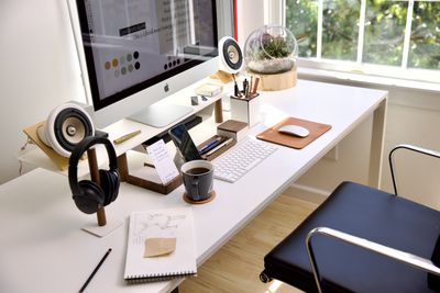 Several organizational devices on a white desk, with an iMac on top.