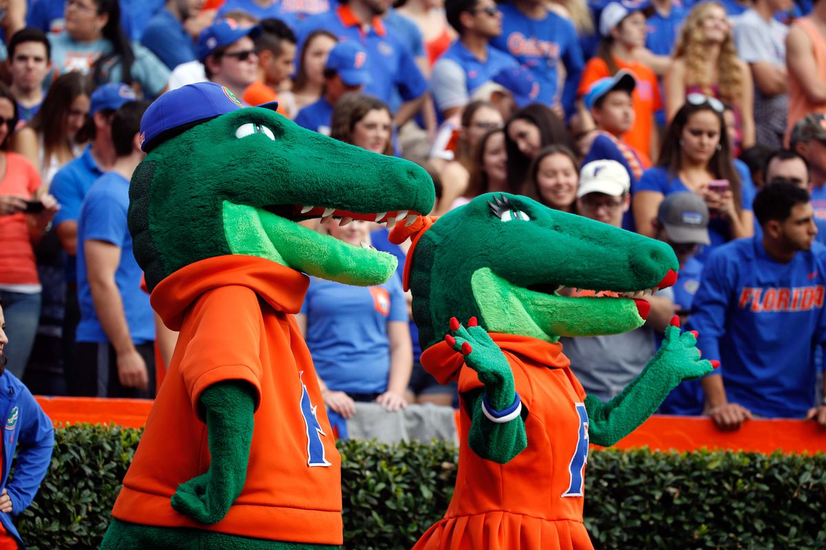Florida mascots Albert and Alberta stand on the Florida sideline with a stadium full of fans in the background.