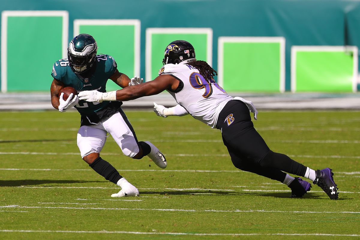 Miles Sanders of the Philadelphia Eagles runs for a four yard gain against Pernell McPhee of the Baltimore Ravens during the first quarter at Lincoln Financial Field on October 18, 2020 in Philadelphia, Pennsylvania.