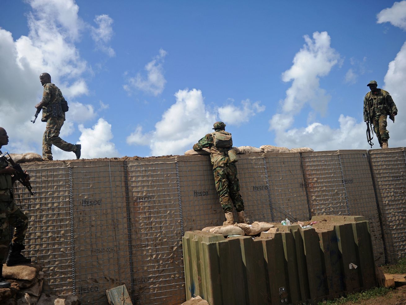 Soldiers atop a barricade wall.