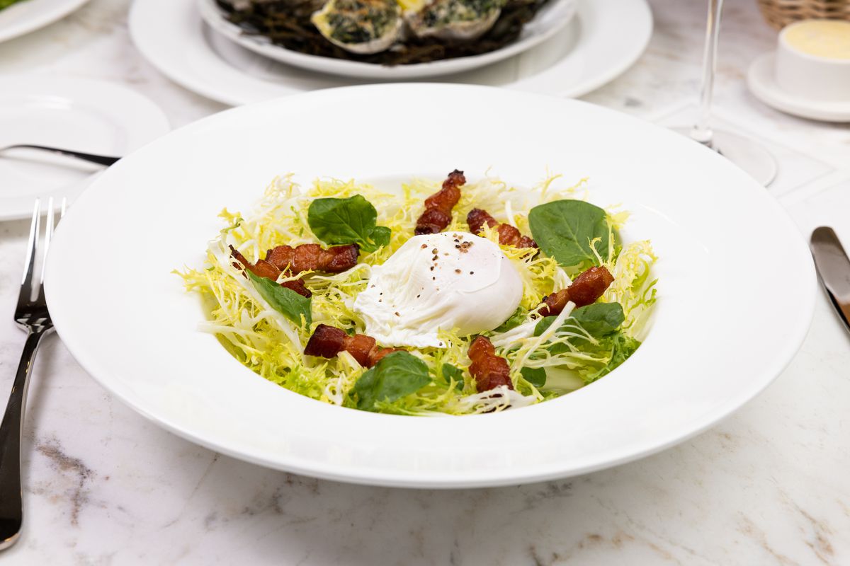 Salad with bacon lardons, poached egg and lemon Dijon vinaigrette&nbsp;