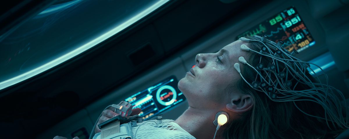 Mélanie Laurent lying back in her cryo-pod, with electrical leads attached to her head, in Oxygen