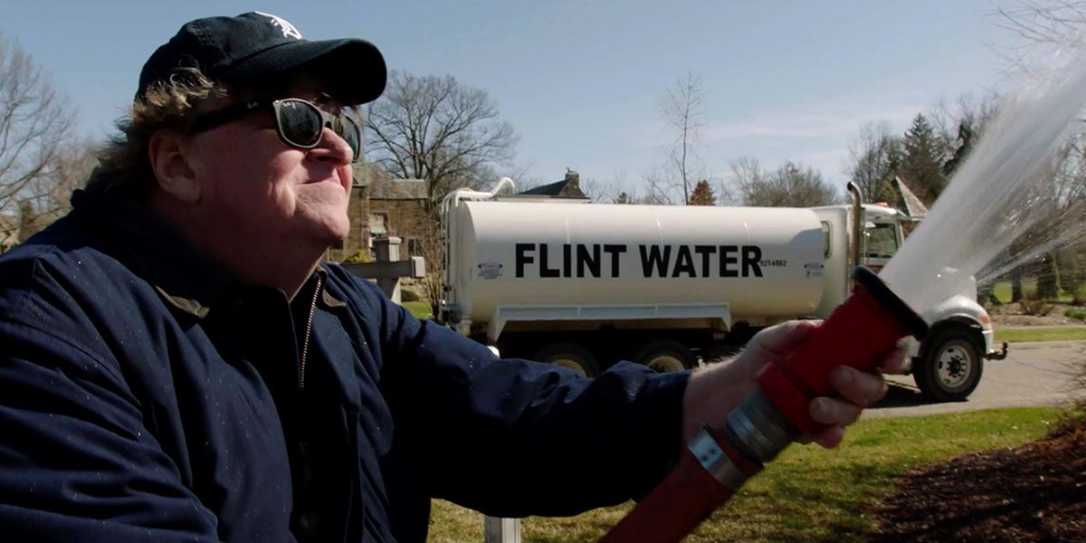 Moore sprays water from Flint, Michigan on Governor Rick Snyder’s mansion in his new documentary Fahrenheit 11/9.
