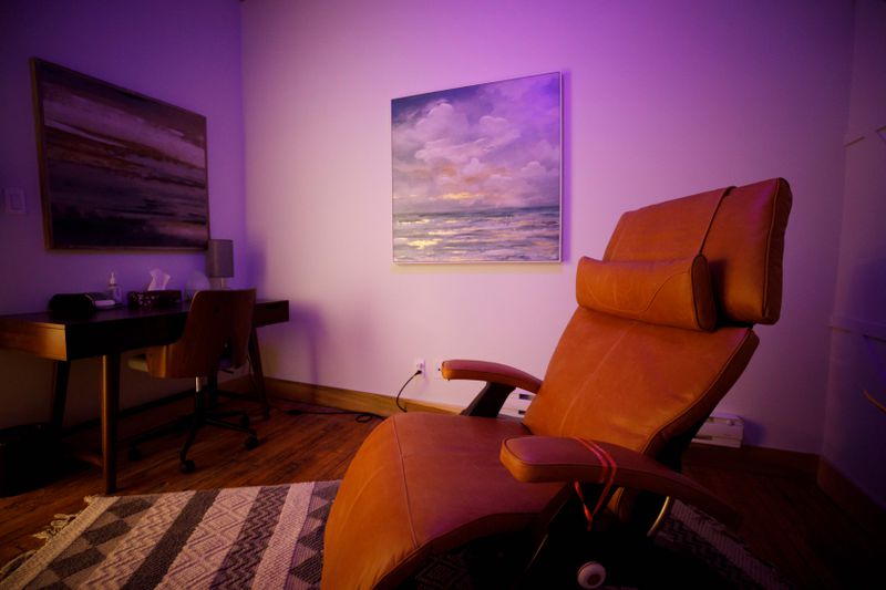 A comfortable chair with warm lighting in a room used for psychedelic therapy.