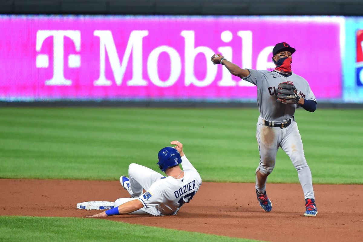 Francisco Lindor #12 of the Cleveland Indians turns a double play against Hunter Dozier #17 of the Kansas City Royals in the seventh inning at Kauffman Stadium on September 2, 2020 in Kansas City, Missouri.