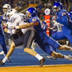 Boise State wide receiver Thomas Sperbeck (82) tackles Brigham Young punter Jonny Linehan (31) during the first half of an NCAA football game between Boise State and Brigham Young in Boise on Thursday, Oct. 20, 2016. 