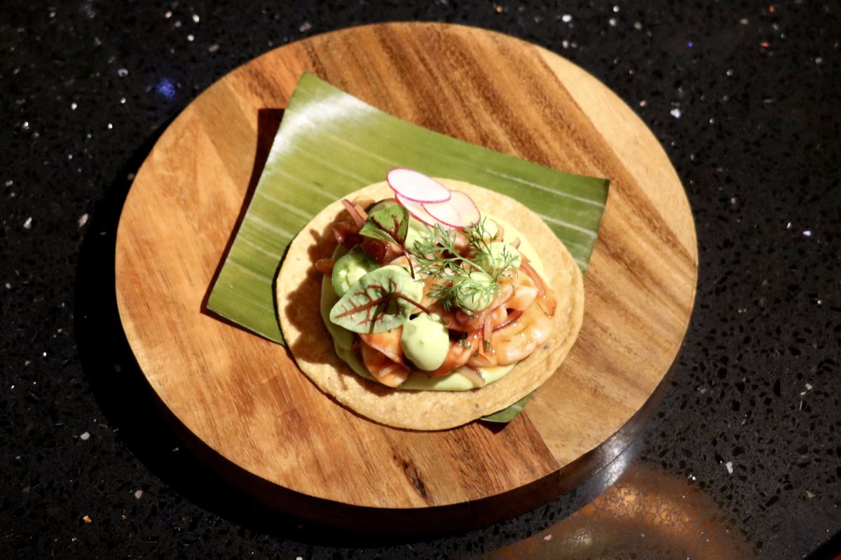 A tostada with octopus, shrimp, shaved radish, and other garnishes.